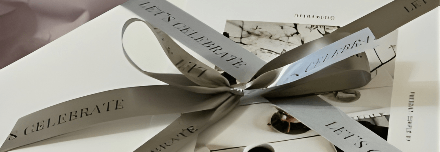 minimal gift wrapping with ribbon featuring words like celebrate and life